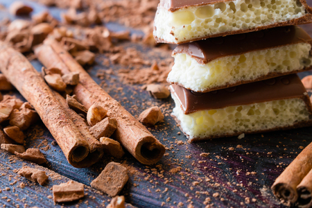 porous chocolate on a background of cinnamon and cocoa nutsの写真素材