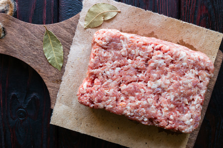minced meat on a cutting board on a black background