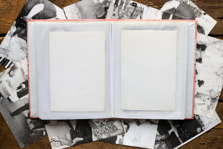 photo album and old black and white photos on a wooden background mockup