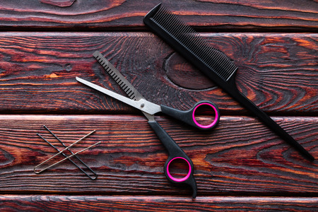 scissors and comb hairdresser tools on a wooden backgroundの写真素材