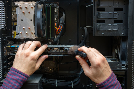 man cleans the dust from computer hardwareの写真素材