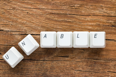 the word unable of the keyboard keys on a wooden backgroundの写真素材