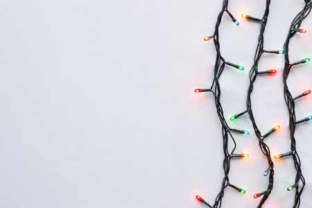 luminous garlands lying on a white background with space for textの写真素材