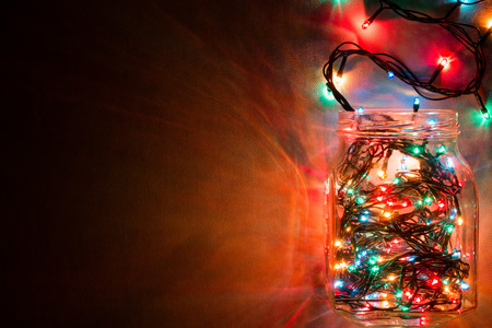 glass jar with a glowing garland top view. space for textの写真素材