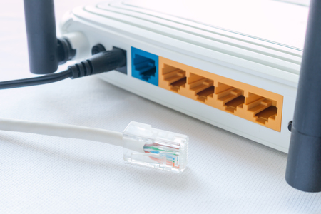 internet cable and a router on a white backgroundの写真素材