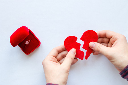 man holding broken heart next to the wedding ring