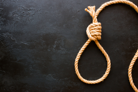 running knot of rope on a black background with space for text. Concept stop suicideの写真素材