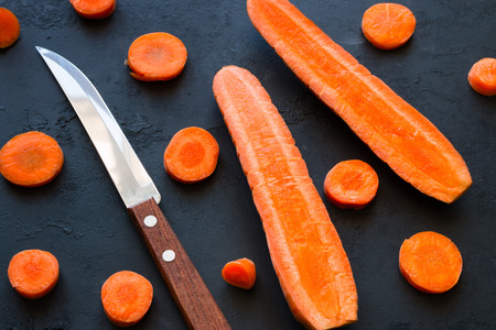 Kitchen knife and carrots on a black backgroundの写真素材