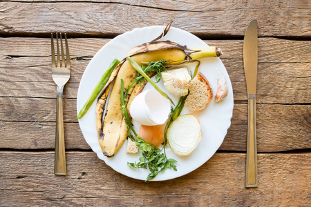 Dish with food waste and cutlery on a wooden backgroundの写真素材