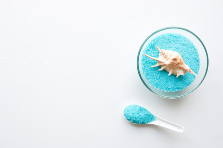 blue bath salt and seashell on white background with place for textの写真素材