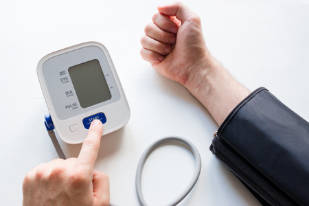 man measures his blood pressure with a tonometerの写真素材