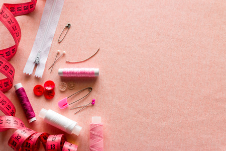 Sewing accessories on a pink background with space for textの写真素材