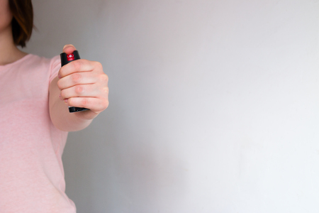 girl holds a self-defense pepper sprayの写真素材