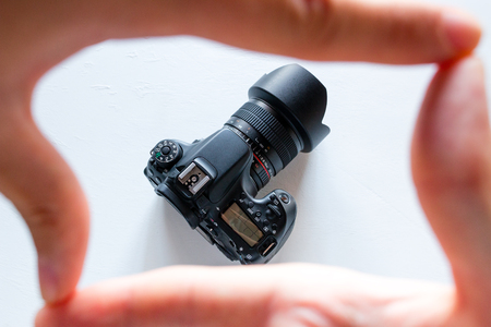 photo camera in a frame of fingers on a white background