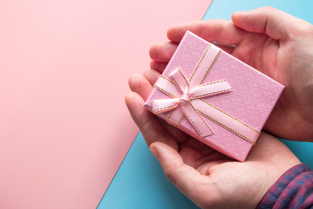 man holding a pink gift box on valentines dayの写真素材