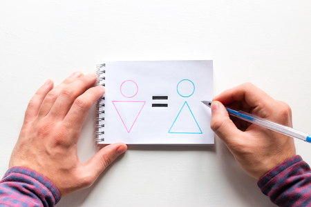 man draws gender equality in a notebook on a white backgroundの写真素材