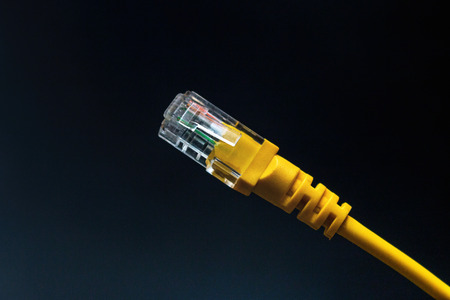 yellow network internet cable on black background close-up
