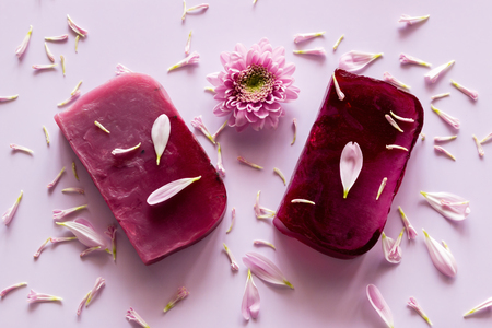 homemade natural soap on a colored background with flower petalsの写真素材