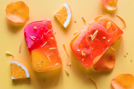 homemade natural soap on a yellow background with flower petalsの写真素材