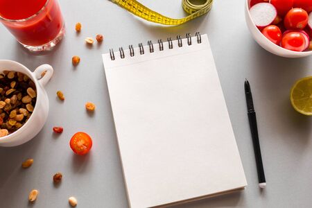 notebook with place for text to write calories and fresh vegetables on a white backgroundの写真素材