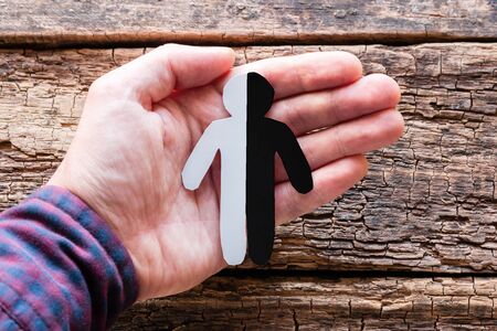 black and white silhouette in hand on a wooden background. anti-racism concept, stop discrimination