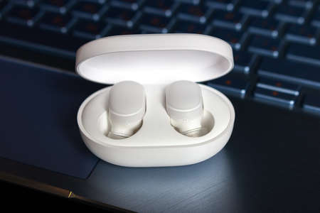 wireless  headphones on a charge on a laptop background