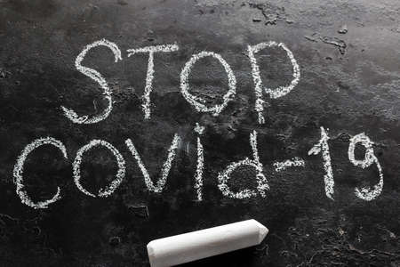 chalk inscription stop covid-19 on a black backgroundの写真素材