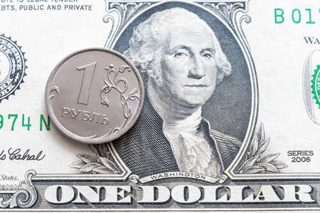 one ruble coin against the background of one dollar with a portrait of Washington
