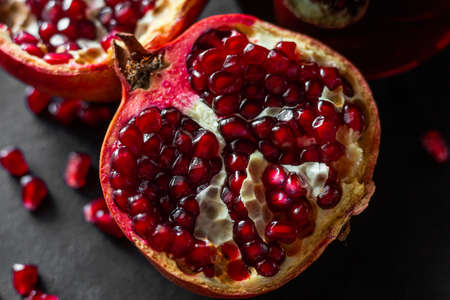 fresh pomegranate fruit and seeds close-up on a black backgroundの写真素材