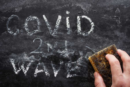 erases the inscription second wave covid on a black backgroundの写真素材