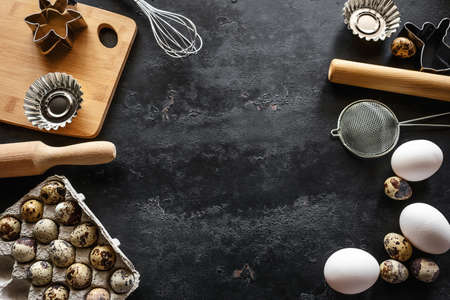 ingredients and utensils for baking on black background with place for text