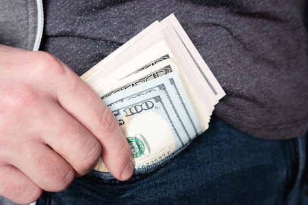 man pulls money out of his pocket close-upの写真素材