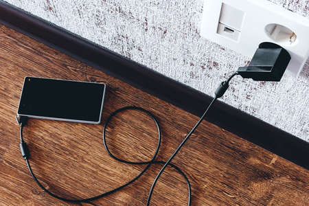 phone charging in the apartment on the floorの写真素材
