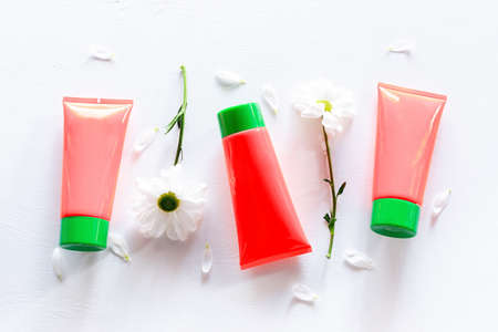 bottles with natural cosmetics, ointment and flowers with place for text mockupの写真素材