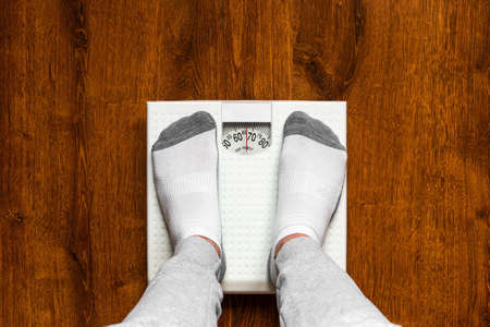 man standing on the scales concept healthy eating bodybuildingの写真素材