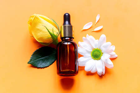 perfume and flowers on an orange background close upの写真素材