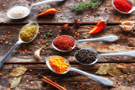 spices in tablespoons and herbs on a wooden background close-upの写真素材