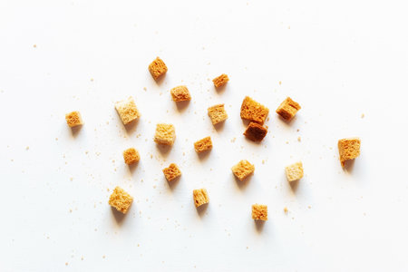 scattered crumbs of roasted white bread on a white backgroundの写真素材