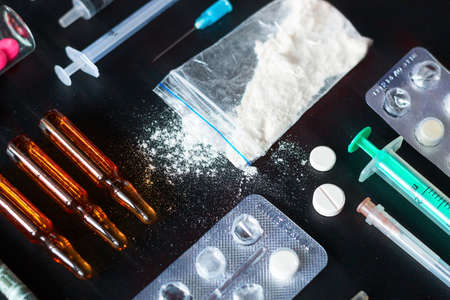 set of addict drugs, syringe, pills, money concept addiction habit close up