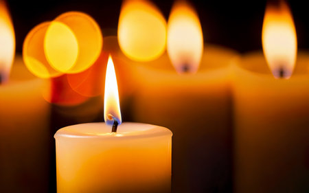 yellow burning candle on bokeh background close upの素材