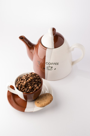 Cup of roasted brown coffee beans on white backgroundの写真素材