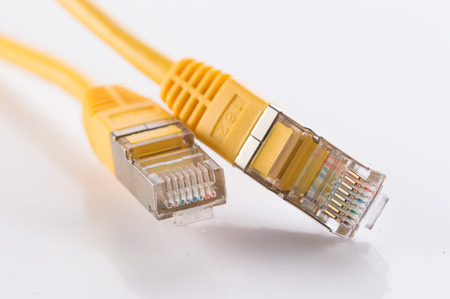 Yellow FTP cable on white reflective surface,with focus on connectors 