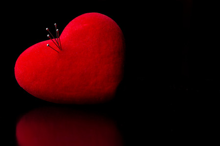 Red heart with pins on dark backgroundの写真素材