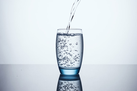 Water Glass on Gray Background with clean reflection 