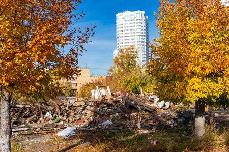 Ruins of demolished old wooden private house against the background of new multi-story residential...