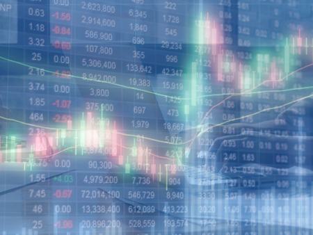 Double exposure of stocks market chart and stock data in blue on LED display with women hand using laptop computer background.の写真素材