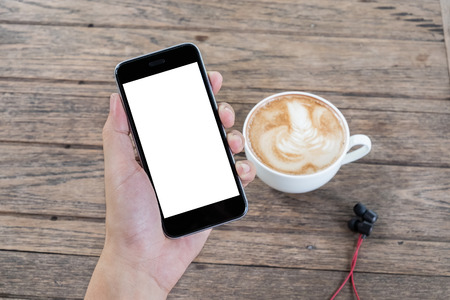 Close up of a man using smart phone with blank mobile and cup of coffee .Smart phone with blank screen and can be add your texts or others on smart phone.の写真素材