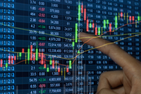 A city business man pointing on laptop screen device to check stocks and market data. selective focus.の写真素材