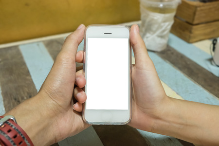 Close up of a man and woman holding smart phone with blank mobile and cup of coffee .Smart phone with blank screen and can be add your texts or others on smart phone.の写真素材