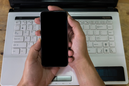 Close up of a man using smart phone with blank mobile and cup of coffee .Smart phone with blank screen and can be add your texts or others on smart phone.の写真素材